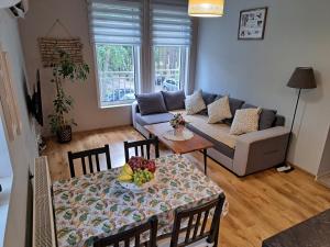 a living room with a table and a couch at Apartament nad Jeziorem Sławskim in Radzyń