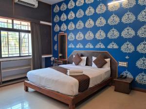a bedroom with a bed and a blue wall at Advaitha Serenity Resorts in Kālvādi +84 photos