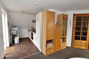 a kitchen with a white refrigerator and wooden cabinets at Schwedenhaus Westensee 2 OG in Groß Vollstedt