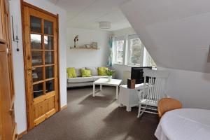 a room with a bed and a living room with a couch at Schwedenhaus Westensee 2 OG in Groß Vollstedt