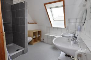 a bathroom with two sinks and a shower at Schwedenhaus Westensee 2 OG in Groß Vollstedt +4 photos
