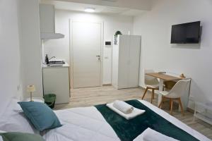 a bedroom with a bed and a table and a kitchen at Casa Sangiorgio Srl in Treviglio