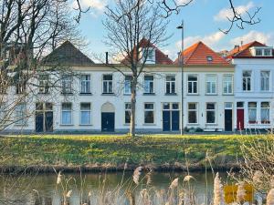 a large white building next to a body of water at Breda Apartment w Kitchen & Private Bathroom 2p in Breda