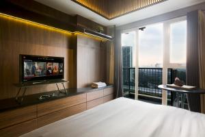 a bedroom with a bed and a tv and a window at Futura Studio-Modern Apartment near CBD BSD in Serpong