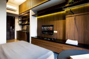 a bedroom with a bed and a tv on a wall at Futura Studio-Modern Apartment near CBD BSD in Serpong