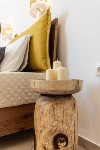 a table with three candles in a room with a bed at Sunshine in Naxos Chora