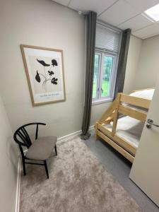 a bedroom with a bed and a chair and a window at Åsen Apartment, Stamsund in Stamsund