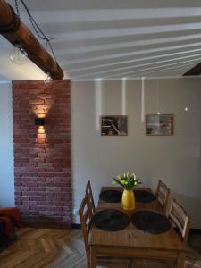 a dining room with a table and a brick wall at Apartament Wiaduktowy in Srebrna Góra +21 photos