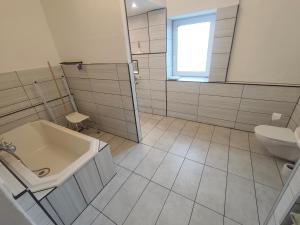 a bathroom with a tub and a sink and a toilet at Ferienwohnung Alte Fleischerei in Lauchhammer +7 photos