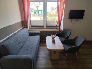 a living room with a couch and two chairs and a table at Ferienwohnung Alte Fleischerei in Lauchhammer