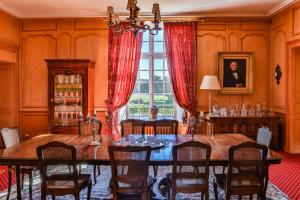 a dining room with a table and chairs and a window at Chateau de Vaux in Yvré-lʼÉvêque