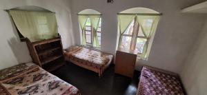 a room with two beds and two windows at Saraswati Kunj in mayapur