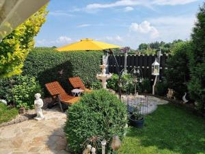 a patio with a yellow umbrella and a fountain at Sonnenhaus in Neuenkirchen