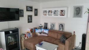 a living room with a brown couch and a tv at Sonnenhaus in Neuenkirchen