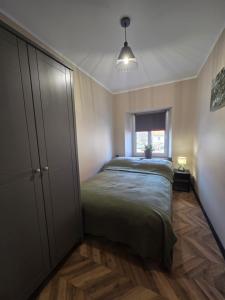 a bedroom with a bed and a cabinet and a window at Apartament Wiaduktowy in Srebrna Góra