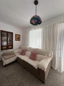 a living room with a couch in front of a window at Casa de la abuela Tere Caminito del Rey, Valle de Abdalajís, Málaga in Valle de Abdalagís