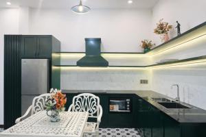 a kitchen with a table and chairs and a sink at Victoria Villa 2 in Hue