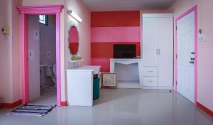 a bathroom with pink and white walls and a sink at Grand Leo Hotel in Khon Kaen