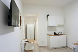 a white kitchen with a desk and a tv at Casa Sangiorgio Srl in Treviglio
