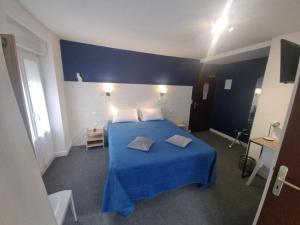 a bedroom with a blue bed with two pillows on it at Hôtel Relais des Vosges in Monthureux-sur-Saône +15 photos
