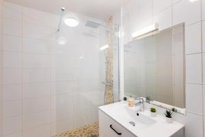 a white bathroom with a sink and a mirror at Le Marnois-Gare in Noisy-le-Grand +18 photos