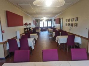 a dining room with white tables and purple chairs at Hôtel Relais des Vosges in Monthureux-sur-Saône