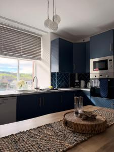 a kitchen with navy blue cabinets and a table at The Old Bank in Moffat