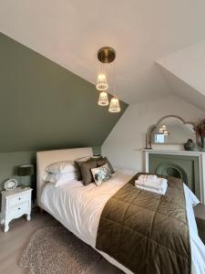 a bedroom with a bed and a green wall at The Old Bank in Moffat