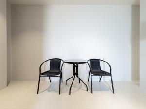 two chairs and a table in a room at On The Six Studios Pratamnak in Pattaya South