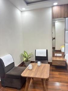 a living room with a couch and a coffee table at Surmila International Hotel in Āsansol