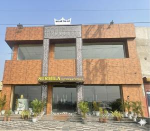 a building with a sign on the front of it at Surmila International Hotel in Āsansol