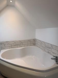 a white bath tub in a bathroom with a tile wall at The Old Bank in Moffat +33 photos