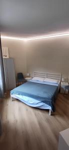 a bedroom with a large bed with a blue blanket at MarcOrio Apartment in Orio al Serio