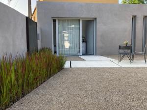 a house with a patio with a table and some grass at Le Studio in Montauban
