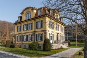 a large yellow house with a roof at Villa Widder - Boutiquehotel in Staatsbad Brückenau