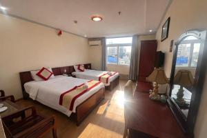 a hotel room with two beds and a television at Khách Sạn Á Châu Cần Thơ in Can Tho
