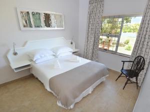 a bedroom with a white bed and a window at Addo River-View Lodge in Colchester