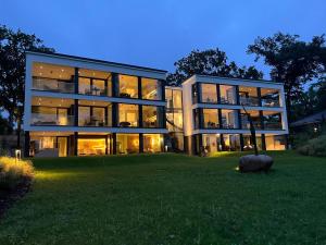 a large glass building with a lawn in front of it at Apartment "Freya" - DECK9 Am Haff in Garz