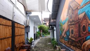 an alley with a mural on the side of a building at Kali Code Home in Yogyakarta