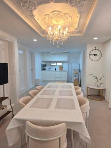 a dining room with a large white table and chairs at 메종 블랑 서울 in Seoul