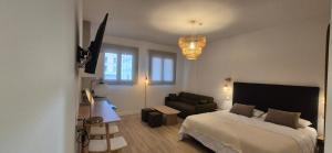 a bedroom with a bed and a couch in it at Las Casitas del Canal Acueducto in Segovia