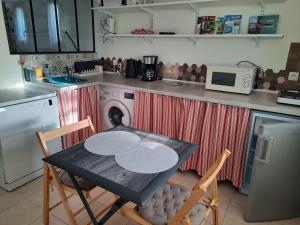 a kitchen with a table and two chairs and a microwave at Les chambres de Noëlla in LʼAiguillon-sur-Vie +12 photos