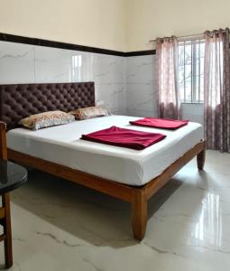 a bed with white sheets and red towels on it at Seaside Residency Murudeshwara in Māvalli +6 photos