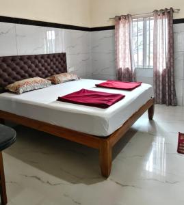 a bed with white sheets and red towels on it at Seaside Residency Murudeshwara in Māvalli