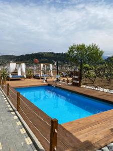 a large swimming pool with a wooden fence around it at Berat Wooden Villas with Private Pool in Berat