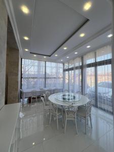 a dining room with tables and chairs and windows at Villa Loft in Balaovit