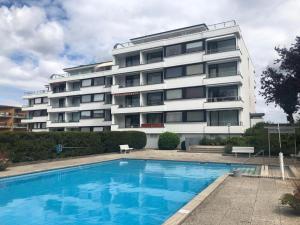 a building with a swimming pool in front of a building at Ostseeblick Apartment 2 in Scharbeutz