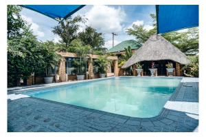 a swimming pool at a resort with a gazebo at Leon's Hotel in Choma