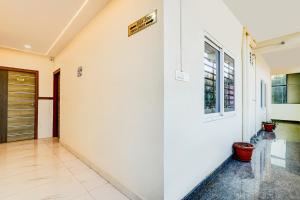 a hallway with white walls and a door at FabHotel Royal Garuda Palace in Bangalore