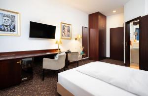 a hotel room with a bed and a desk at City-Hotel Aschaffenburg in Aschaffenburg